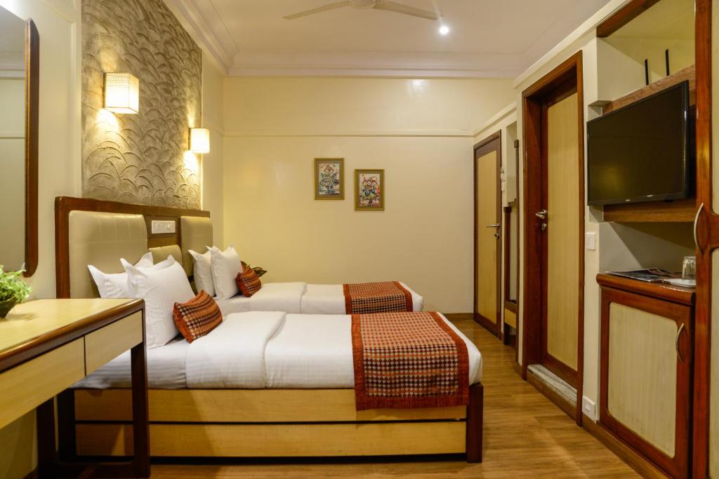 a hotel room with a bed and a television at Hotel Ameya in Mumbai