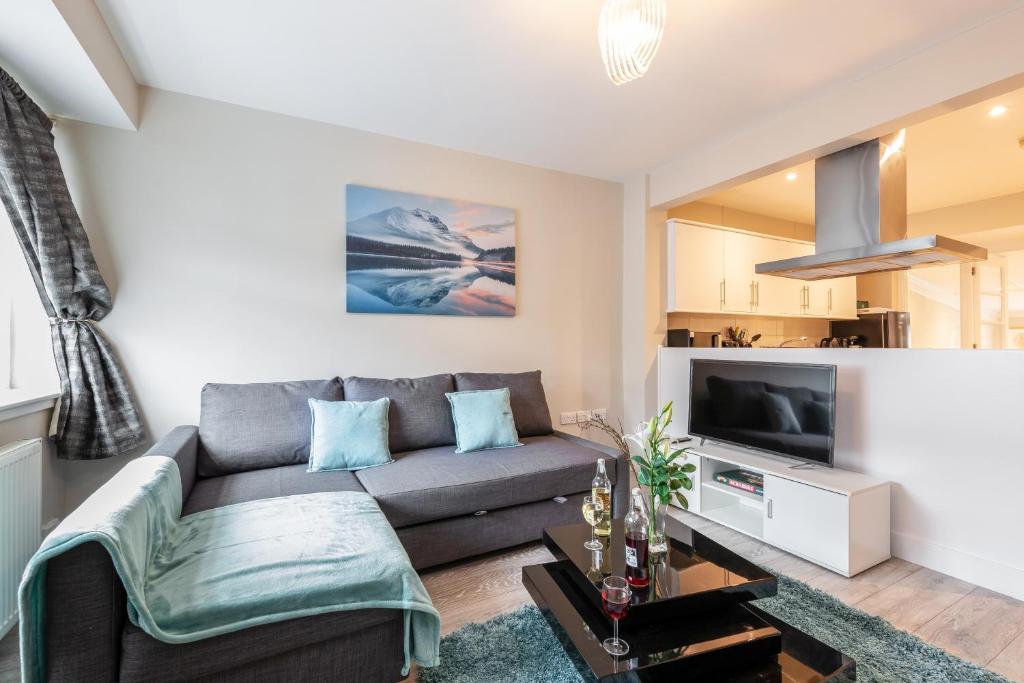 a living room with a couch and a tv at Dartford, Kent - Modern 2Bd 2Bath En-Suite Bungalow M25 Bluewater in Dartford