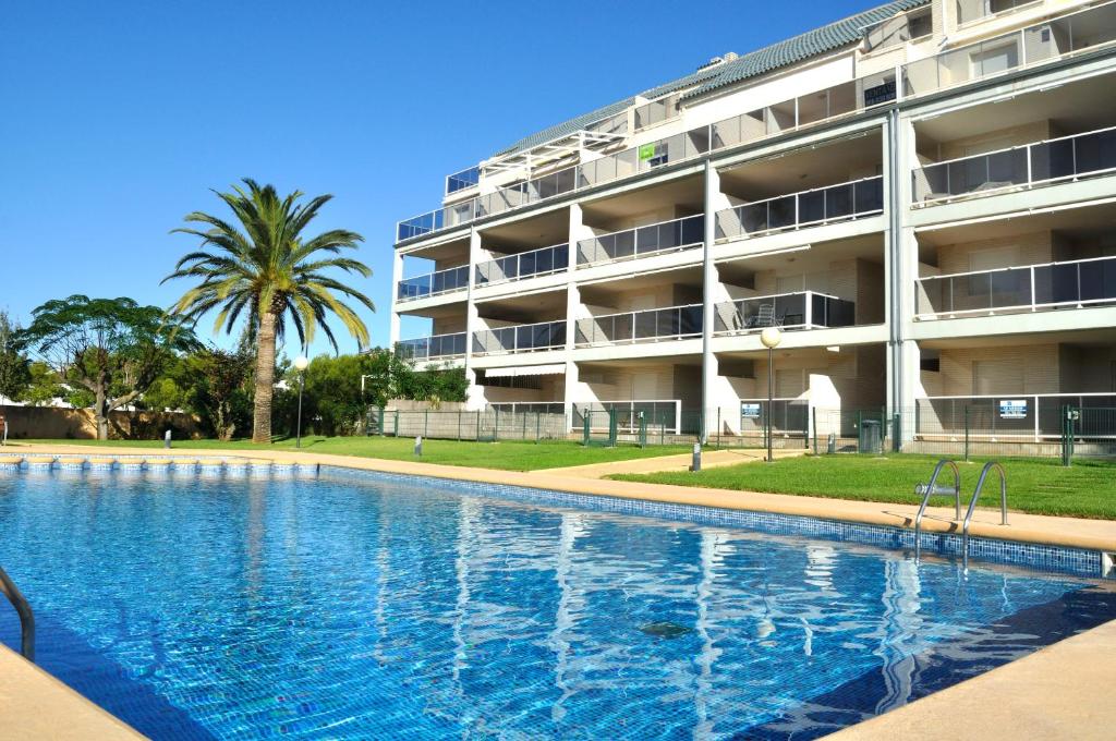 a swimming pool in front of a building at Brisas C8, ático, 3 dormitorios, playa a 50m, by Bookindenia in Denia