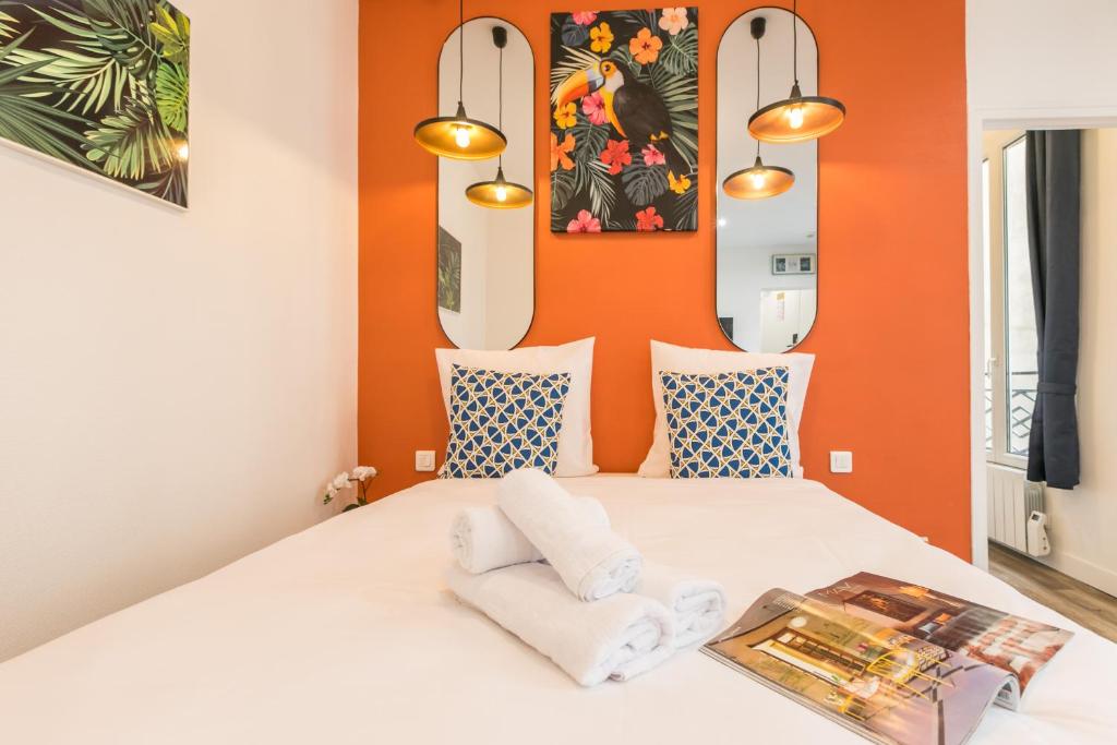 1 dormitorio con 1 cama blanca y paredes de color naranja en Apartments WS Marais - Musée Pompidou, en París