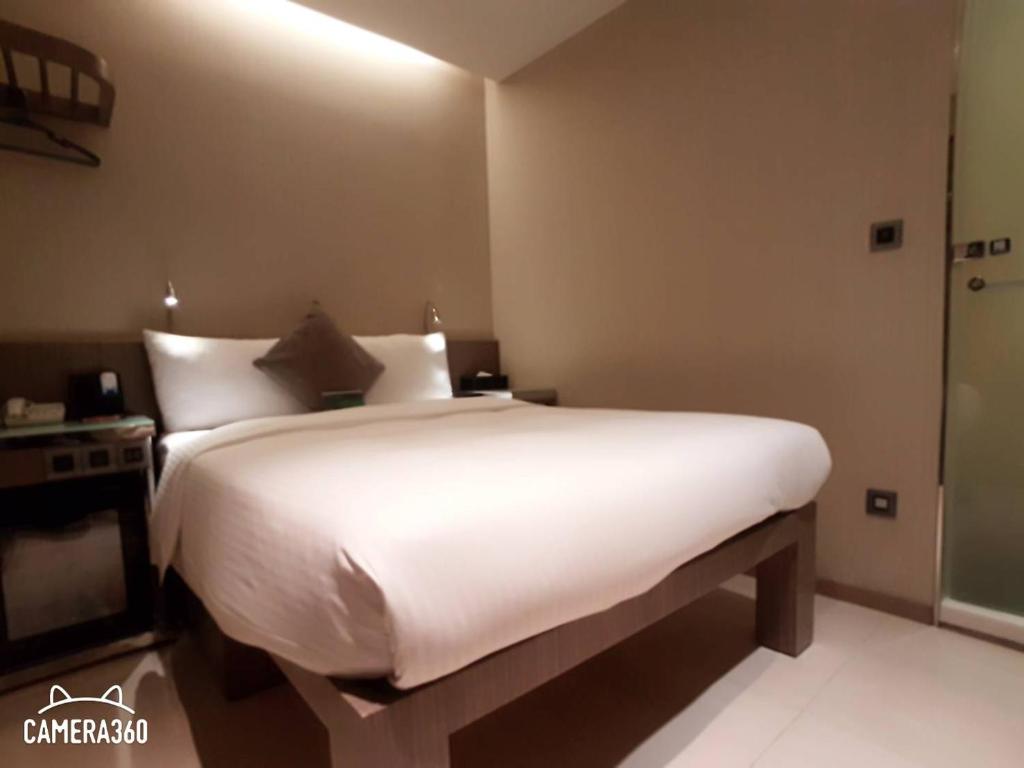 a bedroom with a large white bed in a room at Beauty Hotels Taipei - Hotel B7 in Taipei