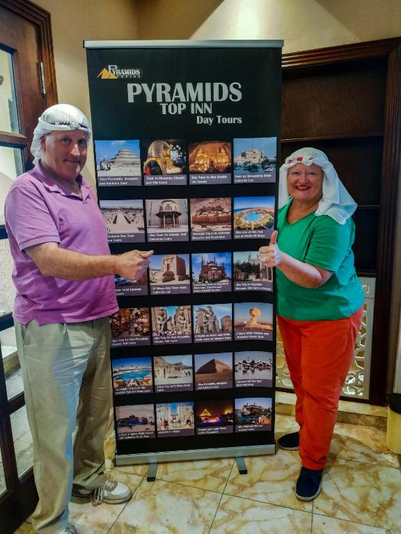 a man and a woman standing next to a sign at Pyramids Top Inn in Cairo