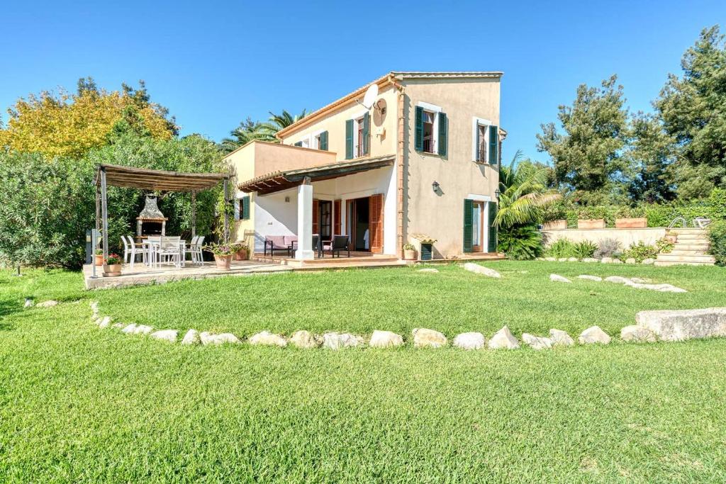 a house with a large yard in front of it at Villa Vertent in Alcudia