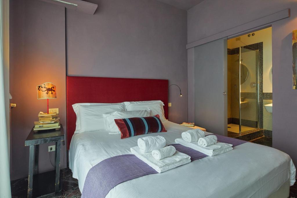 1 dormitorio con 1 cama grande y toallas. en La Terrazza, en Arezzo