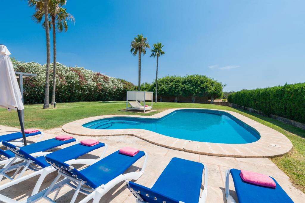 a pool with lounge chairs and a basketball hoop at VILLA CAN RITO in Felanitx