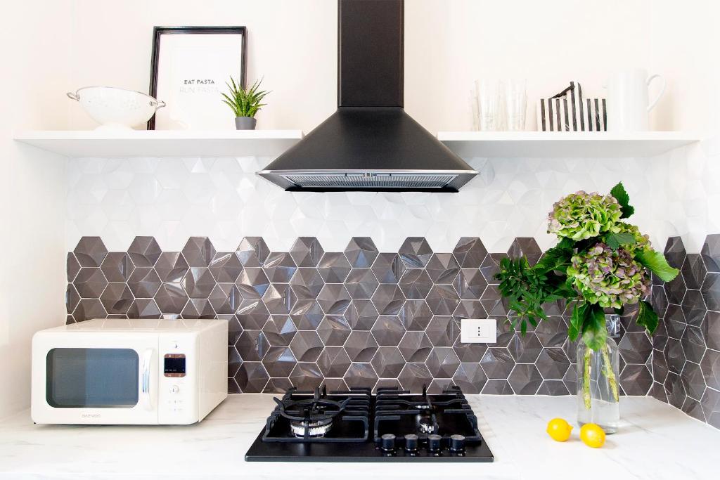 een keuken met een fornuis en een magnetron bij Casa di Artemisia in Rome