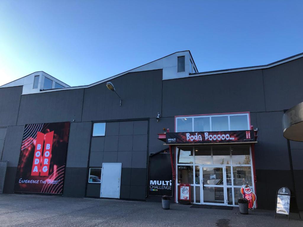 a black building with a pizzaractor sign on it at Multi Challenge Hostel in Östersund