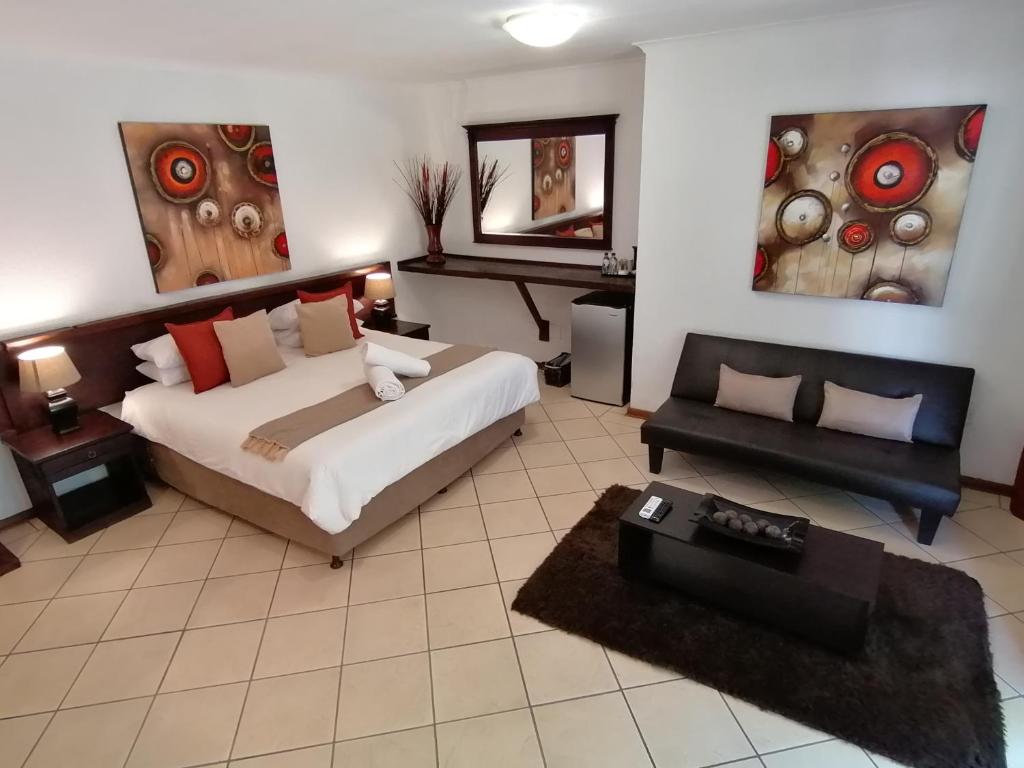 a large bedroom with a bed and a couch at Fourways BnB in Johannesburg