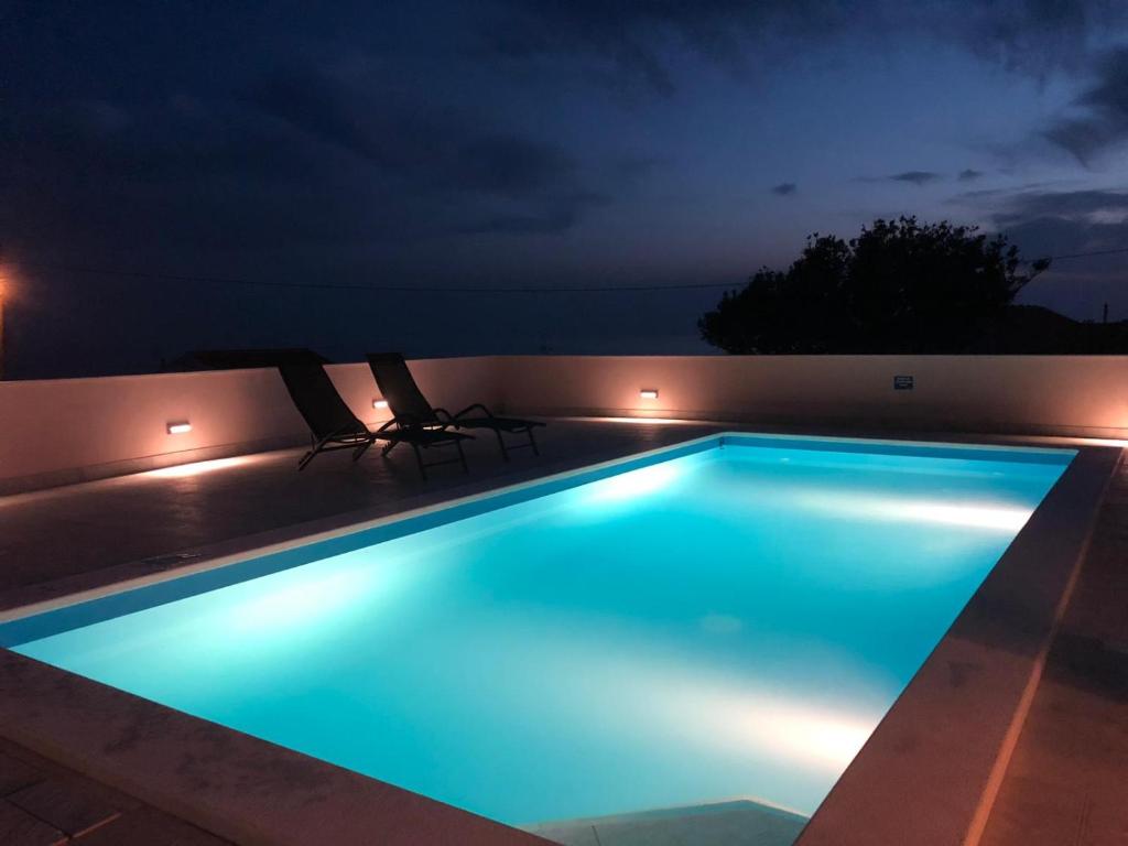 una piscina iluminada por la noche en Villa Daria, en Sevid