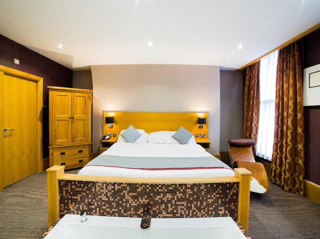 um quarto de hotel com uma cama e uma banheira em OYO Imperial Hotel em Barrow in Furness