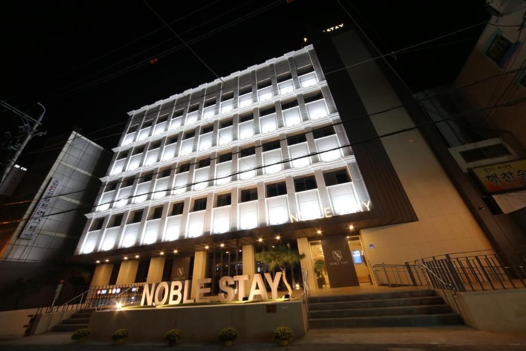 un gran edificio con un cartel delante en Hotel Noblestay en Daegu