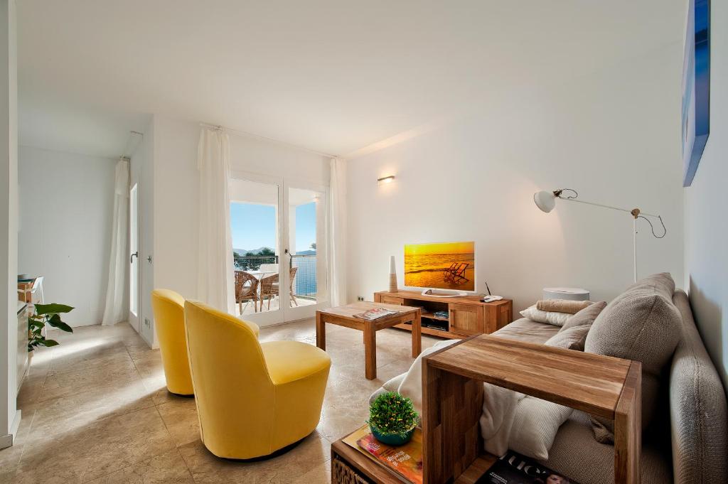ein Wohnzimmer mit einem Sofa, einem Tisch und Stühlen in der Unterkunft Via Alemania 16 Apartment in Port de Pollença