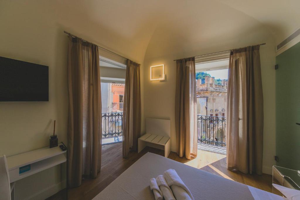 osoba stopa na łóżku w pokoju z balkonem w obiekcie Cefalù Design Suites w Cefalù