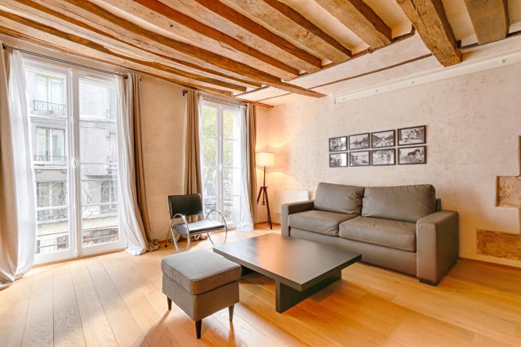 ein Wohnzimmer mit einem Sofa und einem Tisch in der Unterkunft Outstanding Luxury Flat 4P-Boulevard Saint Germain in Paris