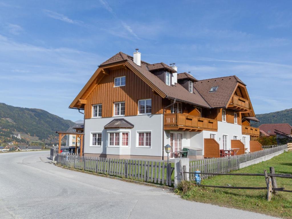 una casa con tetto in legno sul lato di una strada di Apartment in St Margarethen with balcony a Sankt Margarethen im Lungau