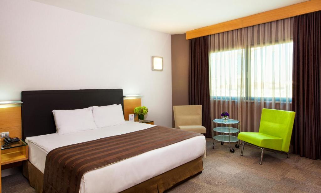 a hotel room with a bed and a green chair at Point Hotel Taksim in Istanbul