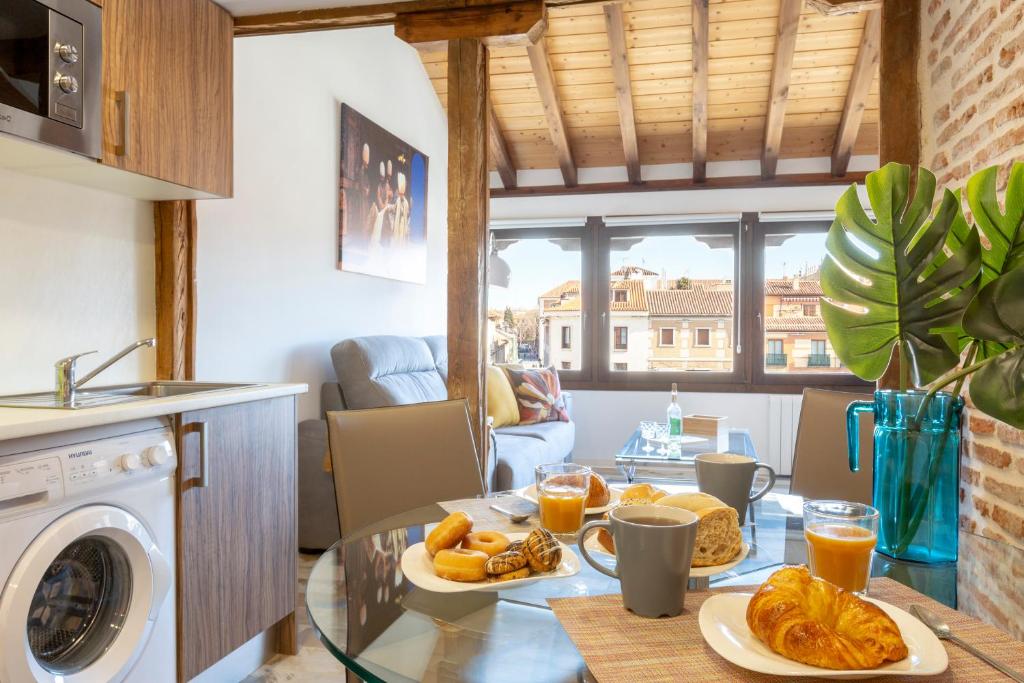 una mesa con platos de comida en la cocina en Apartamentos Ejemplares, en Alcalá de Henares