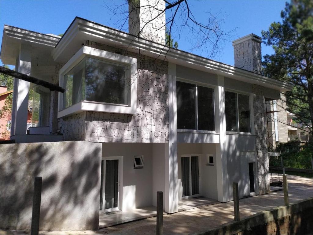 uma casa com uma fachada de pedra e janelas em A VIDA É BELLA em Gramado