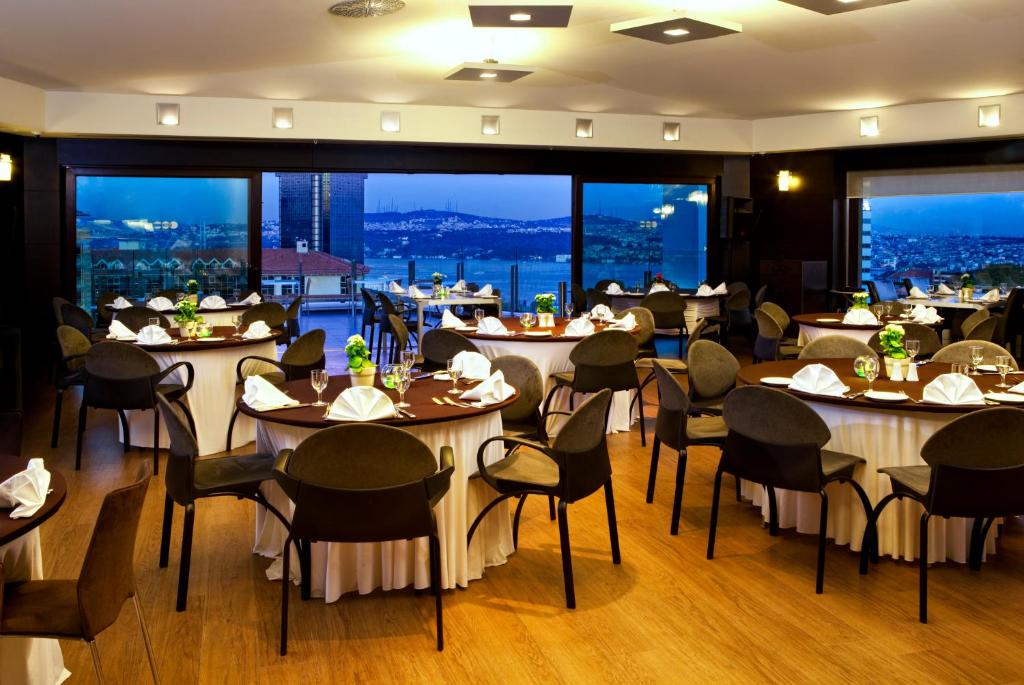 a restaurant with tables and chairs with a view at Point Hotel Taksim in Istanbul