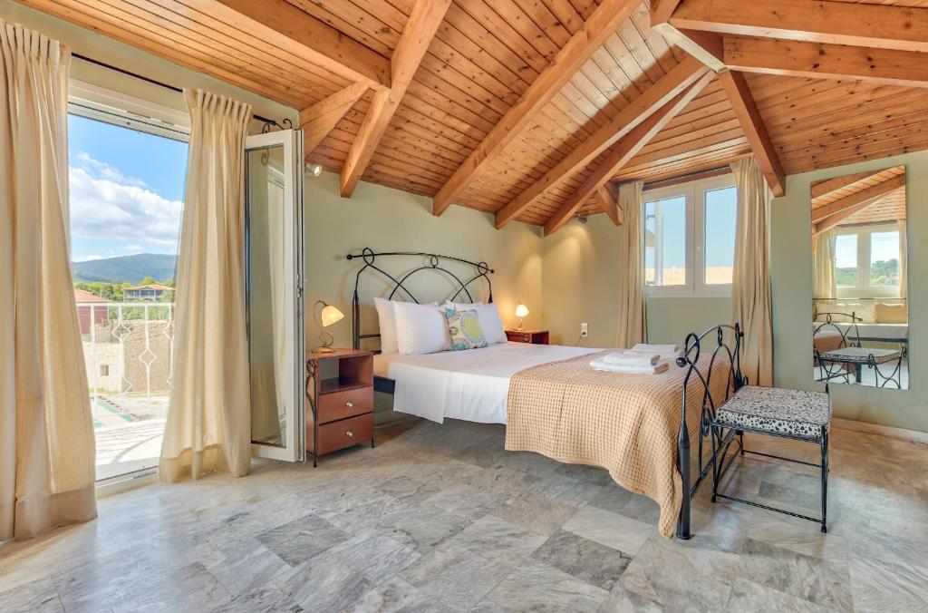 ヴァシリコスにあるAvesta Apartments - 200m from the beachのベッドと大きな窓のある寝室