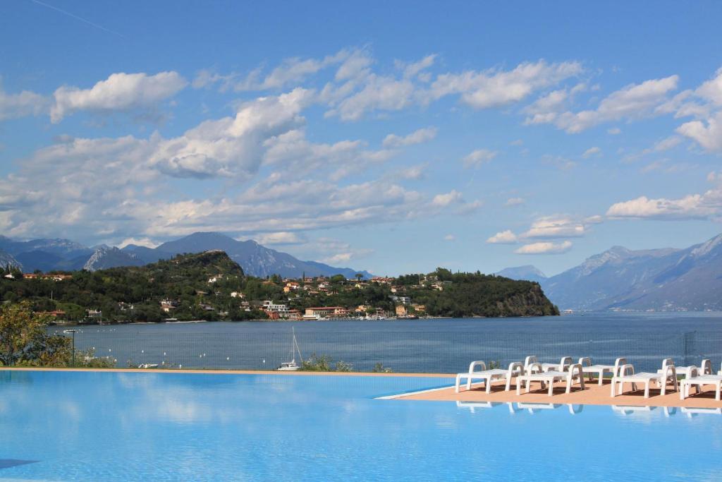un gruppo di sedie su una spiaggia accanto all'acqua di Campeggio Villaggio San Giorgio Vacanze a Manerba del Garda