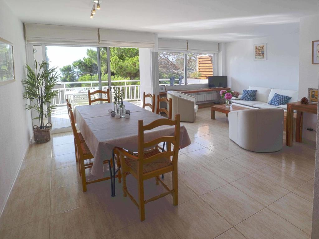 a dining room and living room with a table and chairs at Urcatusa Llevant - Apartamento 6 pax con piscina g27034 in Sant Feliu de Guíxols