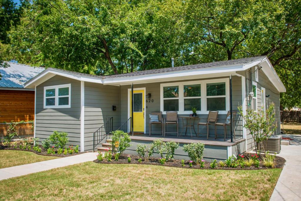 uma pequena casa com um alpendre e um pátio em Walk to the Silos! 3 Bed 1960's Bungalow near Baylor em Waco