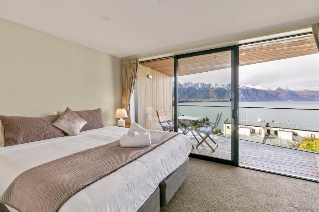 ein Schlafzimmer mit großem Bett und großem Fenster in der Unterkunft Falcon&#39;s View Queenstown in Queenstown