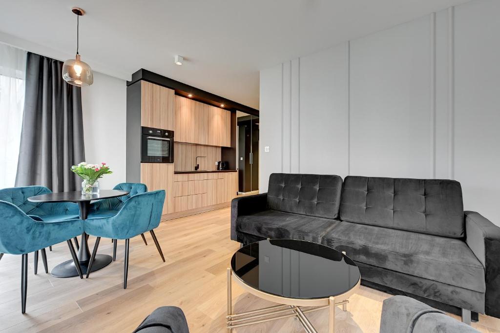 un soggiorno con divano e tavolo di Angielska Grobla Apartinfo Apartments a Danzica
