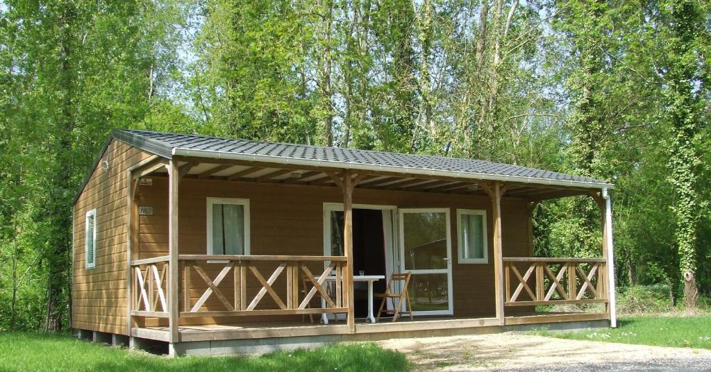 a small cabin with a porch in the woods at Terres de France - Moncontour Active Park in Moncontour-de-Poitou