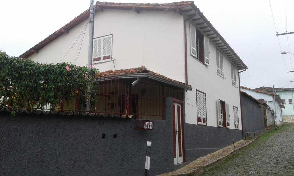 a white house with a gate and a fence at Pousada Dona Denis in Ouro Preto