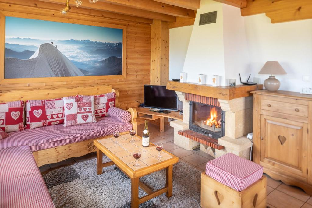 a living room with a couch and a fireplace at Chalet Le Lapye in Les Gets