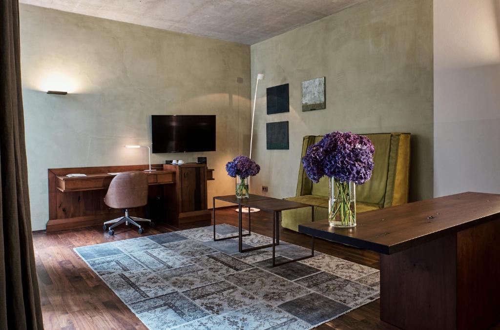 a living room with two vases of purple flowers on a table at Hotel Stary in Kraków
