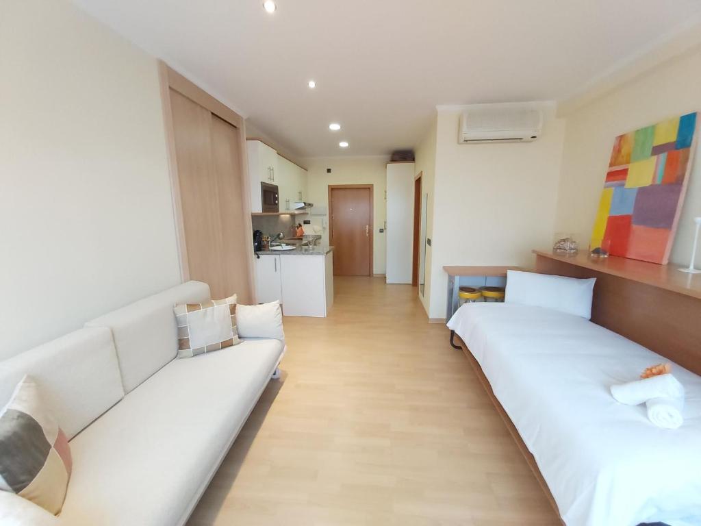 salon z 2 białymi łóżkami i kuchnią w obiekcie Del parque flats estudio martires w Maladze