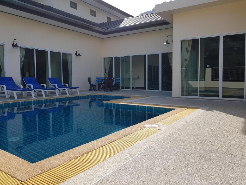 a swimming pool with blue chairs next to a house at ViewPoint Villa in Kathu