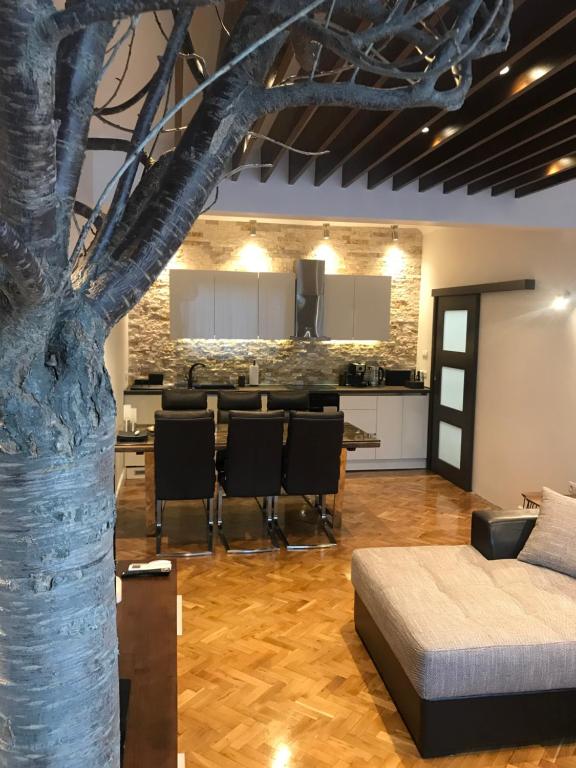 una sala de estar con un árbol en el medio. en Apartment Antique Theatre 2 en Stara Zagora