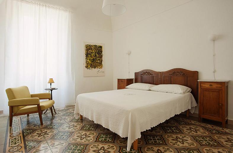 um quarto com uma cama grande e uma cadeira em Dimora Rugiada em Chieti