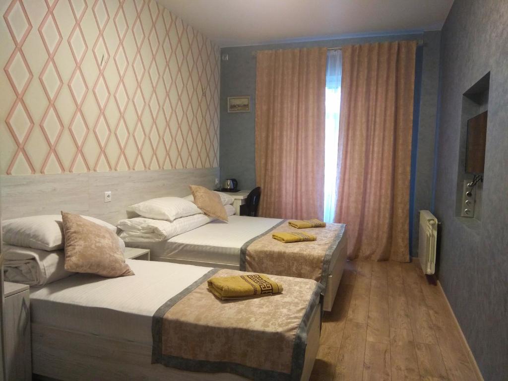 Rivne Hostel في روفنو: غرفة فندقية بسريرين ونافذة