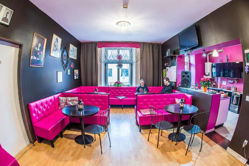 two people sitting in a room with pink furniture at Mohito Hostel in Krakow