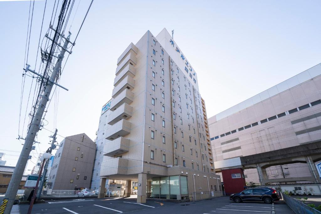 a tall building on a street in a city at Hotel Econo Yokkaichi in Yokkaichi