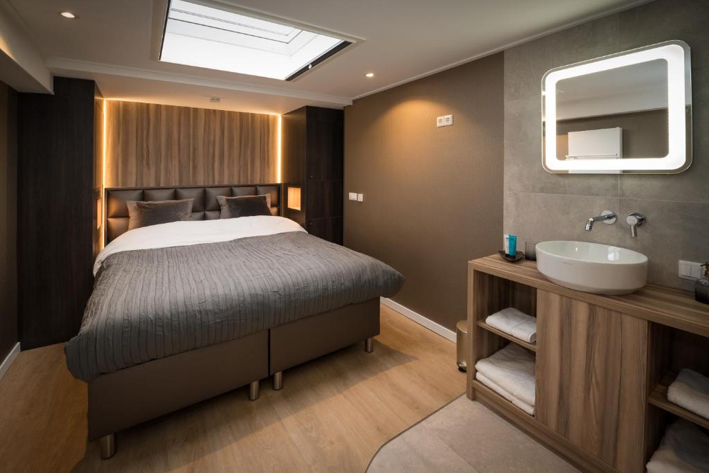 a bedroom with a bed and a sink and a mirror at B&B Centrum Hengelo in Hengelo