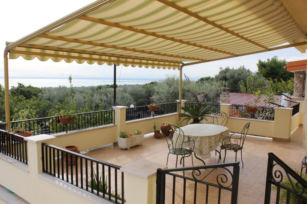 a patio with a table and chairs on a balcony at Home with amazing view in Monte SantʼAngelo