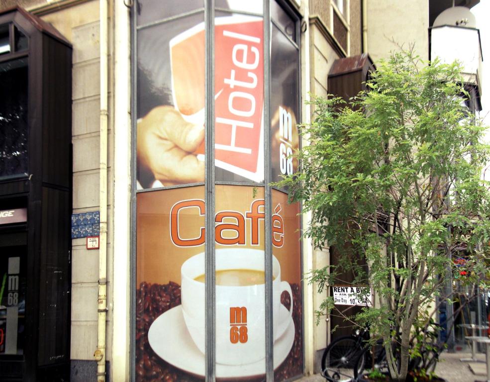 un panneau sur le côté d'un bâtiment avec une tasse de café dans l'établissement Hotel M68, à Berlin