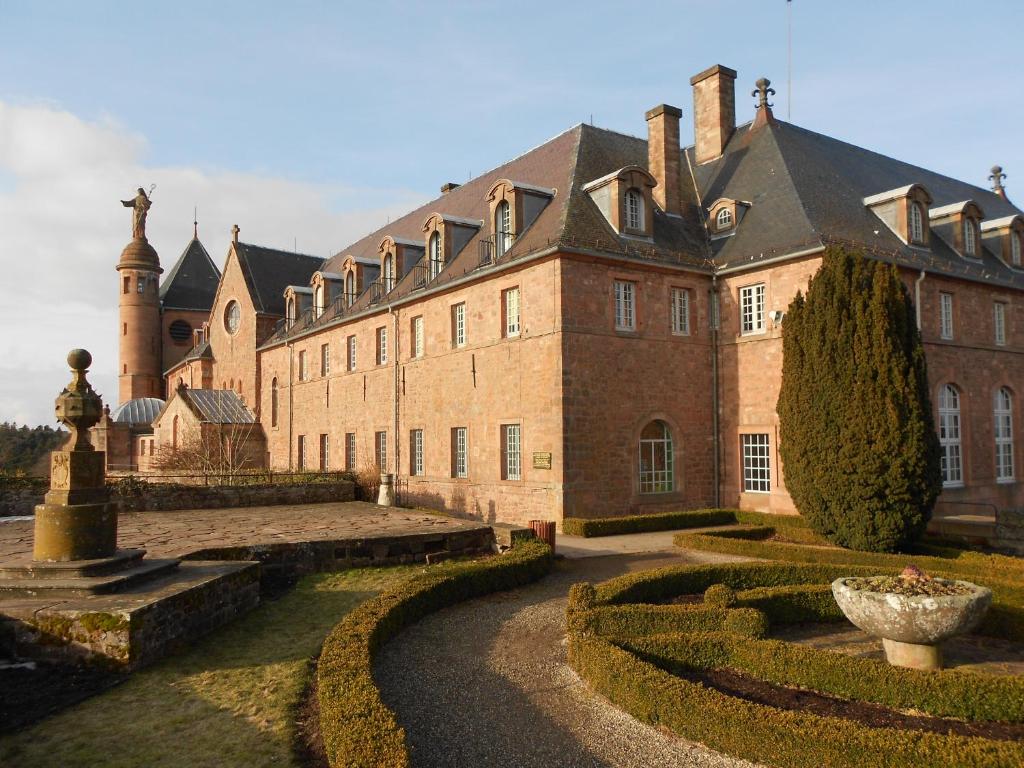 ein großes Backsteingebäude mit einem Garten davor in der Unterkunft Hôtel-Restaurant Mont Sainte-Odile in Ottrott