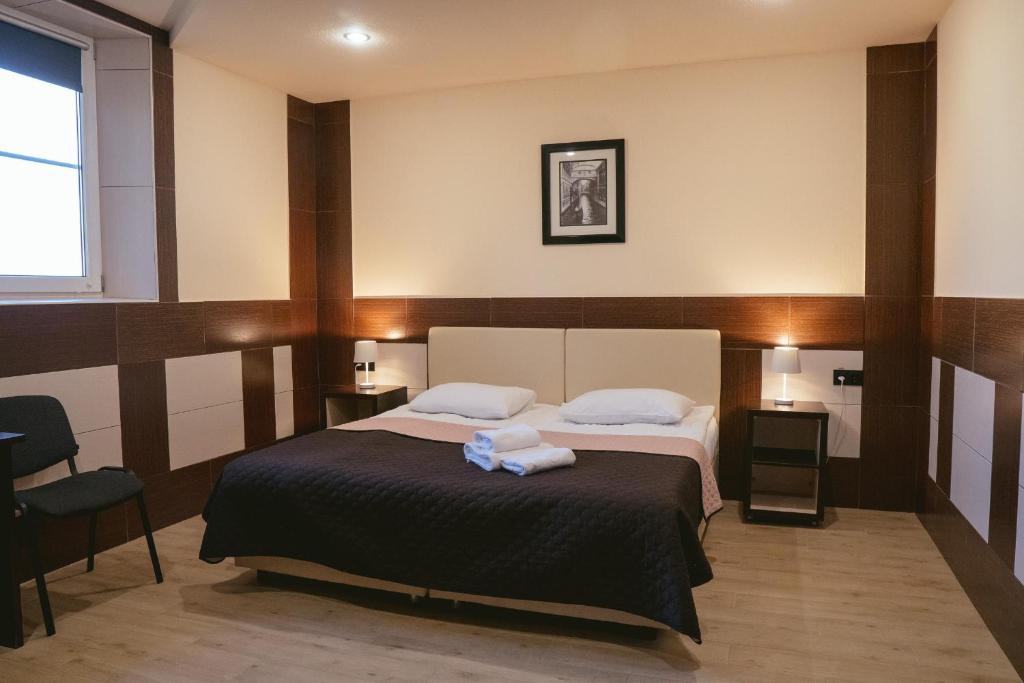 1 dormitorio con 1 cama con 2 toallas en Korona Hotel, en Boryspilʼ