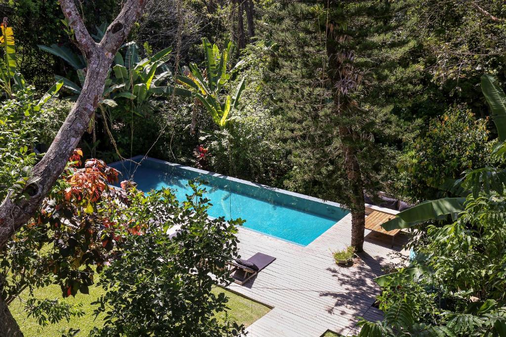 a swimming pool in the middle of a forest at Pousada Seis e Meia in Trancoso
