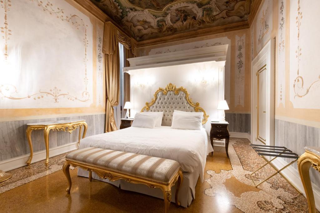 a bedroom with a king sized bed and ornate walls at Ca' Bonfadini Historic Experience in Venice