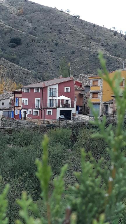 een groep huizen aan de zijkant van een heuvel bij Apartamentos Rurales Camino del Cid in Castejón de las Armas