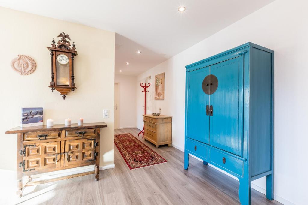 um quarto com um armário azul e uma cómoda e um relógio em LAAX Homes - Casa Coray em Laax