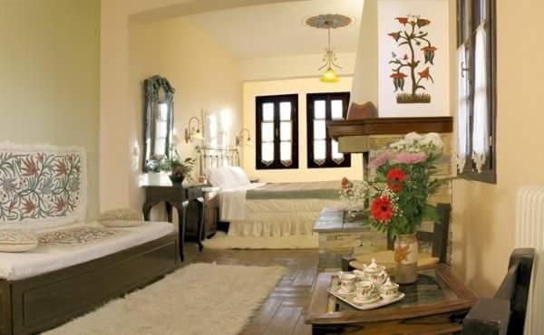 a living room with two beds and a fireplace at Guesthouse Filokalia in Portaria